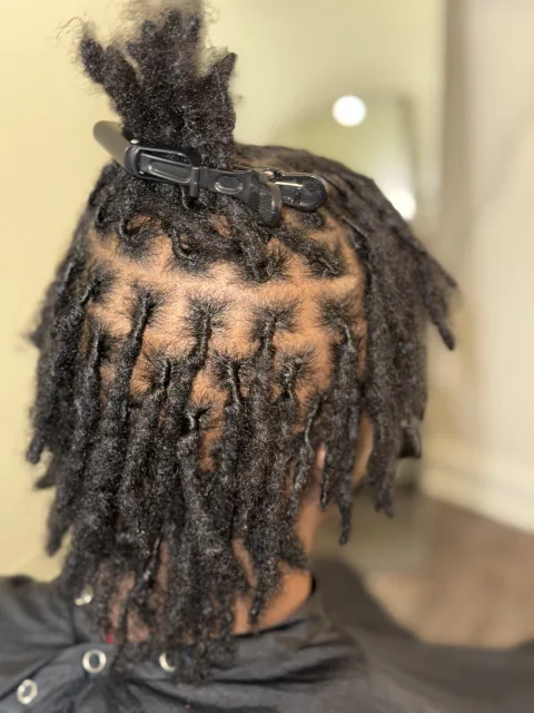 Side view of sectioned short locs with defined parting at September’s Locs