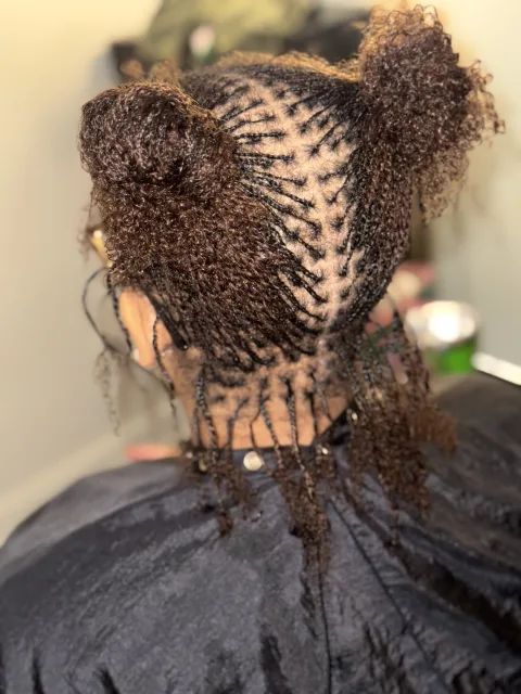 Back view of fine locs arranged in gathered sections at September’s Locs