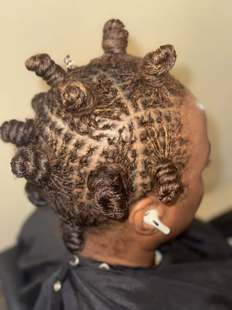 Side view of copper-toned locs arranged in small knots at September’s Locs