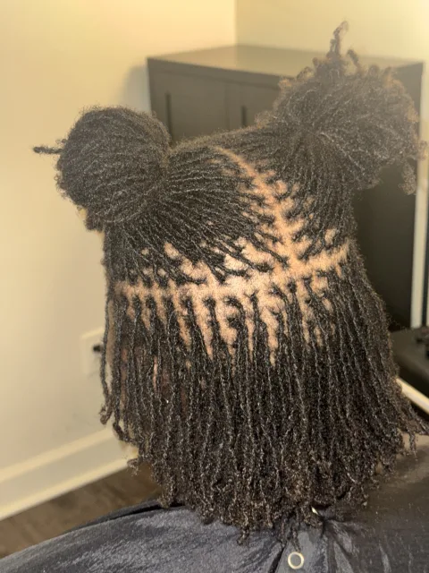 Back view of fine locs with precise parting and two gathered sections at September’s Locs